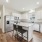 kitchen with island, white cabinets, and window.